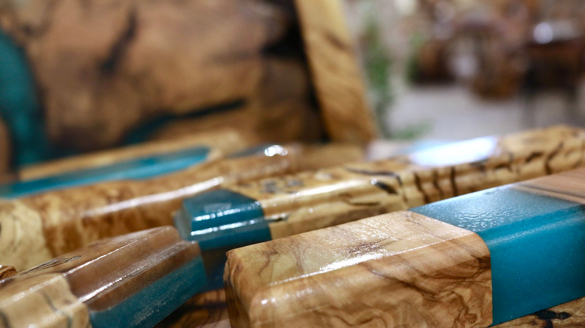 Close-up of olive wood grain meeting turquoise resin on a handmade mezuzah case | MitzvahArt