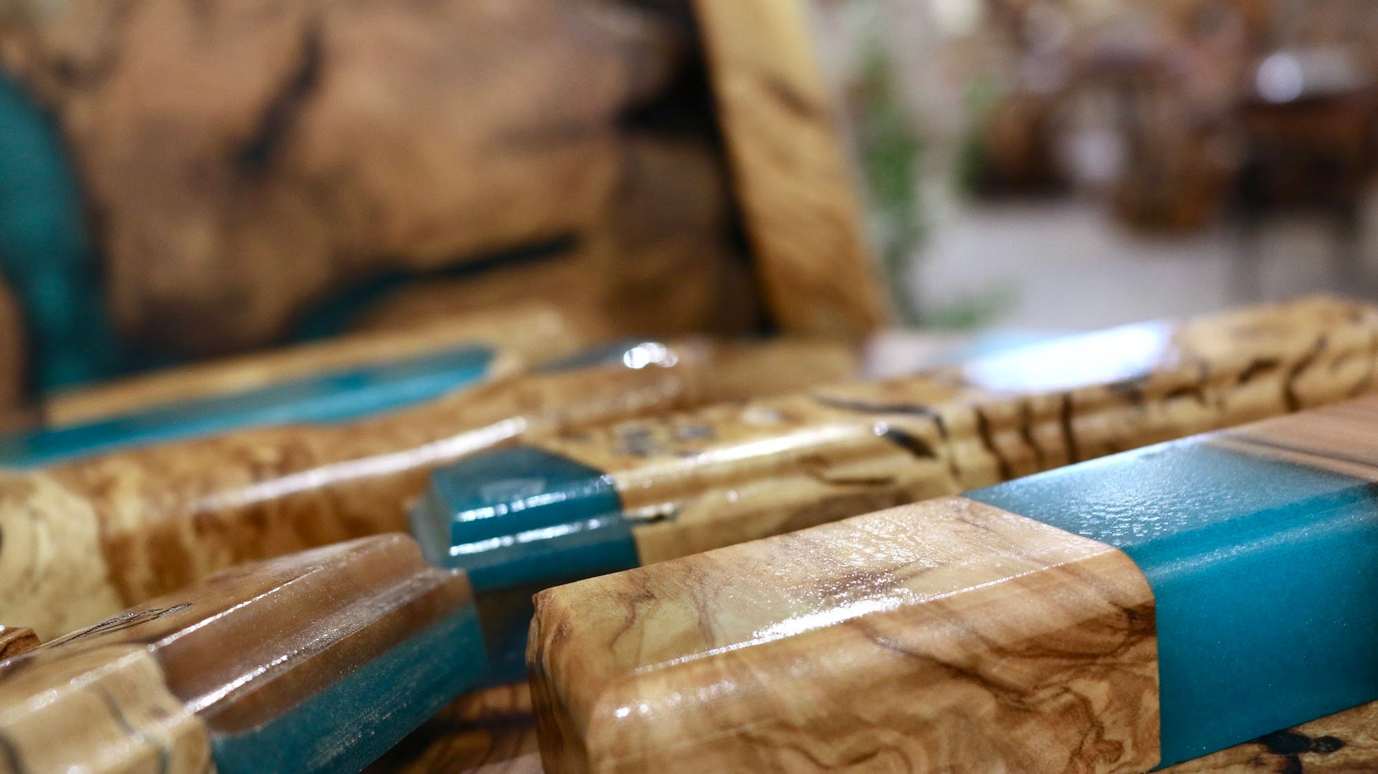 Close-up of olive wood grain meeting turquoise resin on a handmade mezuzah case | MitzvahArt